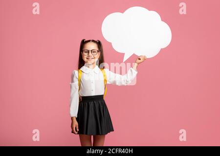 J'ai une idée. Écolière souriante en uniforme avec sac à dos contenant une bulle abstraite Banque D'Images