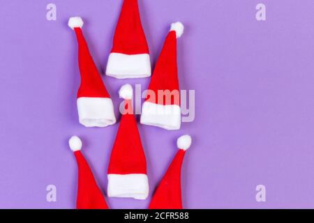 Vue de dessus od rouge élégant Santa hats sur fond coloré. Joyeux Noël concept avec copie espace. Banque D'Images