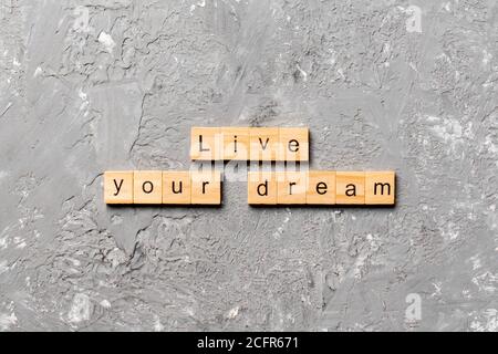 vivez votre mot de rêve écrit sur bloc de bois. vivez votre texte de rêve sur table de ciment pour votre conception. Banque D'Images