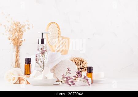 Produits cosmétiques pour le bain et accessoires en bois naturel beige dans un style écologique avec lavande dans un élégant intérieur blanc de salle de bains avec espace de copie. Banque D'Images