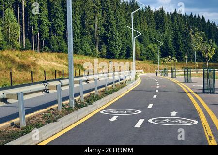 Vue en paysage de la piste cyclable et de la route uniquement pour les piétons. Panneau de signalisation sur les pistes de vélo le long de la forêt montagneuse du lac Banque D'Images