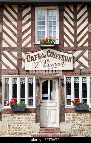 Façade à colombages du 'café du Coiffeur' dans la pittoresque région française Village de Beuvron-en-Auge Banque D'Images