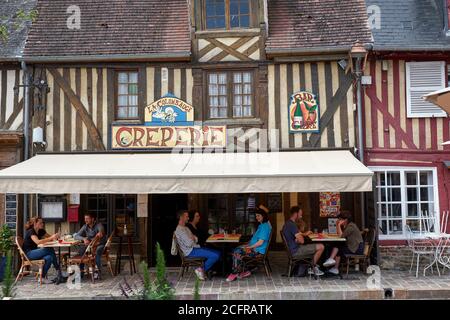 Clients assis sous l'auvent d'une crêperie appelée 'la Colomb' Auge' dans le village pittoresque de Beuvron-en-Auge, en Normandie, en France Banque D'Images