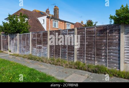 Clôture de jardin en bois utilisant des panneaux de bois horizontaux de style Waney, AKA Overlap et Larch Lap, renforcés par des piliers en béton en Angleterre, au Royaume-Uni. Banque D'Images