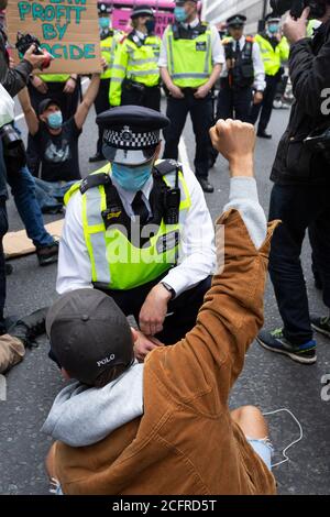 Manifestant lève le poing à la police, bloc de route de la rébellion animale à l'extérieur du ministère de la Santé et des soins sociaux, Londres, 3 septembre 2020 Banque D'Images