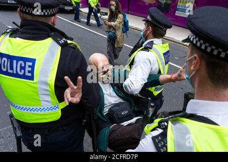 Un manifestant âgé est arrêté à l'arrêt Animal Rebellion Road Block, à l'extérieur du Department of Health and social Care, Londres, le 3 septembre 2020 Banque D'Images