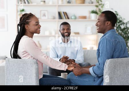 Mariage enregistré. Les heureux conjoints africains tiennent la main après la réconciliation au bureau du conseiller Banque D'Images