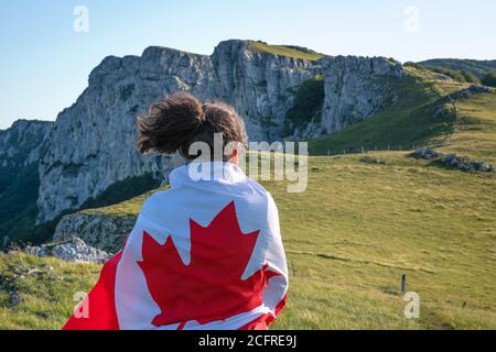 Fête nationale canadienne. 1er juillet. Carte de vœux de la fête du Canada. Jeune femme avec drapeau canadien. Banque D'Images