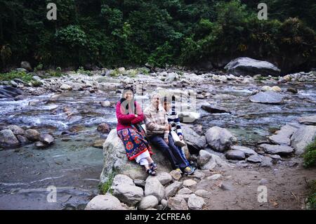 Gros plan d'une famille indienne assise sur les rochers d'une rivière dans les montagnes himalayenne de Gangtok, concentration sélective Banque D'Images