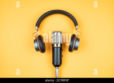 concept de podcasting, directement au-dessus de la vue du casque et du microphone d'enregistrement sur fond orange Banque D'Images