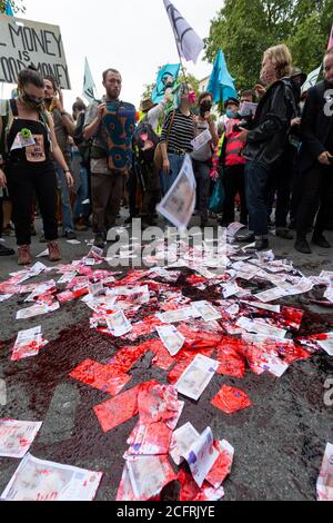 De l'argent trempé dans du sang factice, manifestation de la rébellion d'extinction du « Carnaval de la corruption », Whitehall, Londres, 3 septembre 2020 Banque D'Images