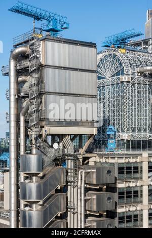 Vue en hauteur de la tour de l'ascenseur et de l'atrium avec grues de nettoyage bleues et escaliers en spirale. Lloyd's Building, Londres, Royaume-Uni. Architecte: Roger Banque D'Images