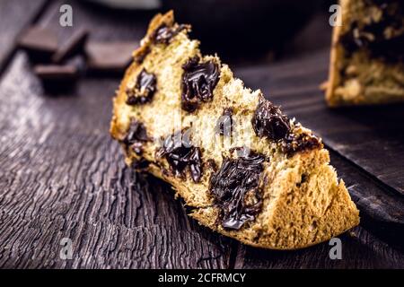 Grande tranche de panettone de chocolat, dessert typiquement brésilien, sur une table rustique en bois. Bonbons de Noël Banque D'Images