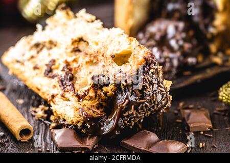 Grande tranche de panettone de chocolat, dessert typiquement brésilien, sur une table rustique en bois. Bonbons de Noël Banque D'Images