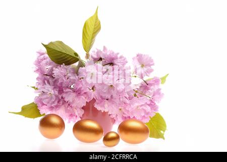 Bouquet de fleurs de sakura rose près de grands et petits oeufs de Pâques isolés sur fond blanc. Concept de printemps et de vacances Banque D'Images