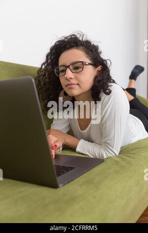 belle femme travaillant à la maison avec un ordinateur, travaillant avec la distance sociale, se détendre Banque D'Images