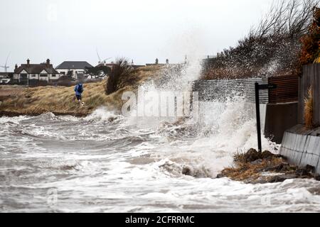 Les randonneurs braving un jour de tempête sur la côte Banque D'Images