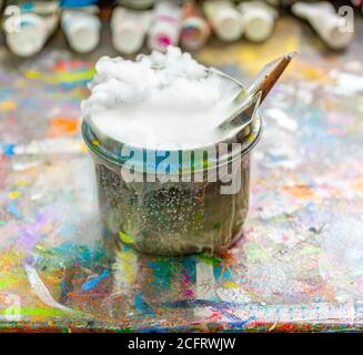 Les brosses de l'artiste dans un contenant d'eau bouillant Banque D'Images
