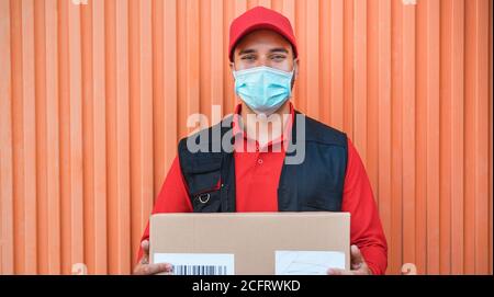 Portrait de l'homme d'accouchement portant un masque de protection du visage pour le coronavirus Prévention de la propagation - Courier au travail pendant la pandémie de Covid 19 heure Banque D'Images