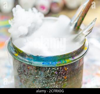 Les brosses de l'artiste dans un contenant d'eau bouillant Banque D'Images