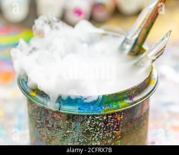Les brosses de l'artiste dans un contenant d'eau bouillant Banque D'Images