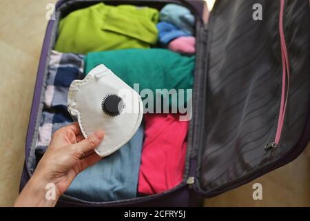 Sac de voyage sûr emballé avec des vêtements et des masques médicaux Banque D'Images