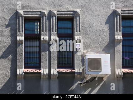 Cracovie. Cracovie. Pologne. Unité extérieure de climatisation sur le mur extérieur de l'ancienne maison en bâtiment entre les fenêtres. Ombres sur la paroi. Banque D'Images