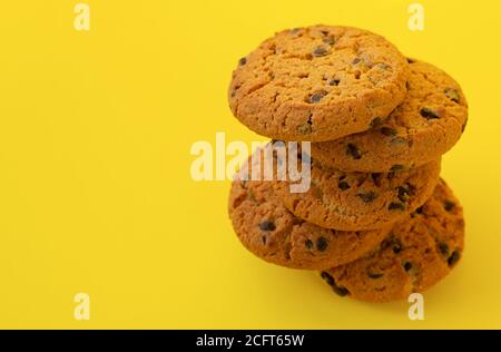 Pile de délicieux biscuits aux pépites de chocolat sur fond de yelllow Banque D'Images