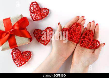 Cœur rouge dans les mains sur fond blanc. Deux coeurs rouges dans les mains sur fond blanc. Symbole de l'amour et des relations. Banque D'Images