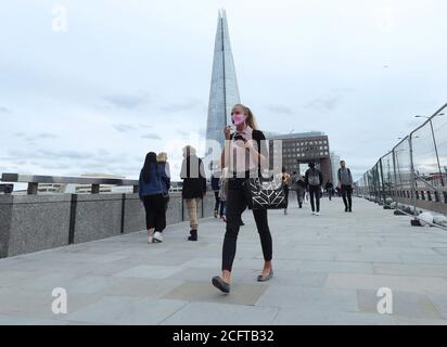 Les navetteurs traversant le London Bridge pendant l'heure de pointe en soirée. Les services ferroviaires ont été mis en service lundi en Angleterre et au pays de Galles et les travailleurs sont encouragés à retourner dans leurs bureaux. Banque D'Images