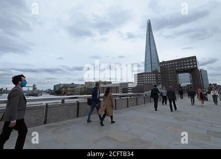 Les navetteurs traversant le London Bridge pendant l'heure de pointe en soirée. Les services ferroviaires ont été mis en service lundi en Angleterre et au pays de Galles et les travailleurs sont encouragés à retourner dans leurs bureaux. Banque D'Images