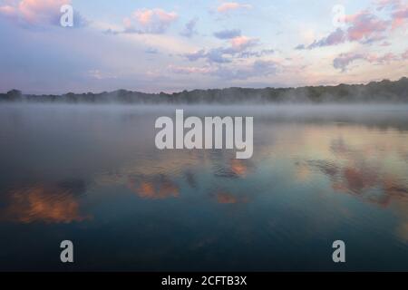 Le brouillard s'élève au large du lac avec un paysage de nuages spectaculaire au lever du soleil créer une ambiance paisible et relaxante avec l'espace de copie Banque D'Images