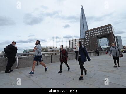 Les navetteurs traversant le London Bridge pendant l'heure de pointe en soirée. Les services ferroviaires ont été mis en service lundi en Angleterre et au pays de Galles et les travailleurs sont encouragés à retourner dans leurs bureaux. Banque D'Images