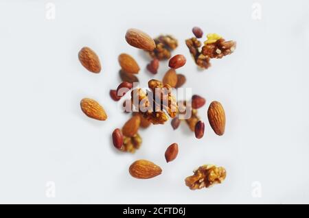 Noix dans l'air sur fond blanc, écrous volants. Alimentation saine, alimentation, protéines, amandes, noix et noisettes cacahuètes Banque D'Images