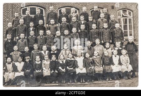 Photo ancienne des camarades de classe. Groupe d'enfants et professeur à l'extérieur. Image vintage avec grain et flou de film d'origine Banque D'Images