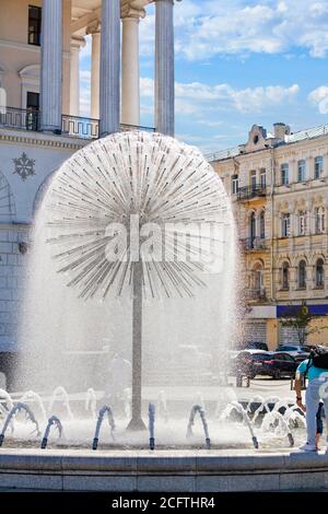 Une belle fontaine de la ville sous la forme d'un immense le pissenlit rafraîchit les gens sur le fond de la façade de la colonne voûtée De la ville de Kiev Banque D'Images