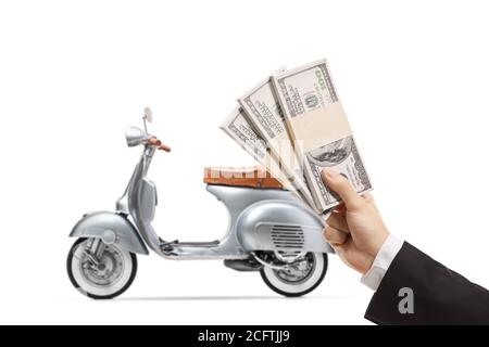 Main d'un jeune homme dans un costume tenant des piles d'argent de us dollar et un scooter d'argent vintage dans le dos isolé sur fond blanc Banque D'Images