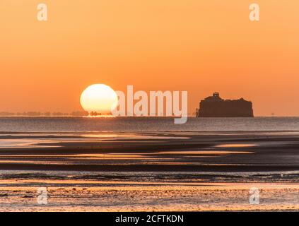 Solent Sunrise. Le soleil se levant à côté du fort de No Man's Land dans le Solent, photographié de Ryde Pier, île de Wight Banque D'Images