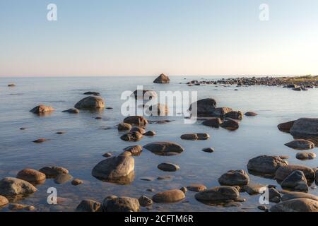 Pierres le long de la côte rosky de mer avec des algues dans l'eau. Banque D'Images