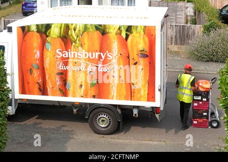 Sainsburys supermarché livraison de fourgon garé vue aérienne conducteur empilement nourriture sur le chariot de la commande en ligne de shopping à la maison Essex Royaume-Uni Banque D'Images