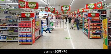 Coronavirus shopping personnes dans Covid 19 masques de visage Asda supermarché magasin de nourriture corona virus social distancer homme avec le port de panier Masque Angleterre Royaume-Uni Banque D'Images