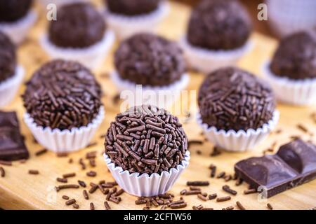 Bonbon de truffe au chocolat brésilien brigadeiro sur une table en bois. Doux typique des fêtes d'enfants Banque D'Images