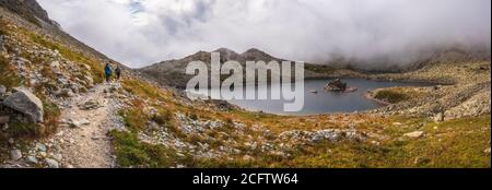 Vue panoramique sur le lac de la montagne de Zabie avec brouillard et touristes sur le sentier de randonnée à High Tatras, Slovaquie Banque D'Images