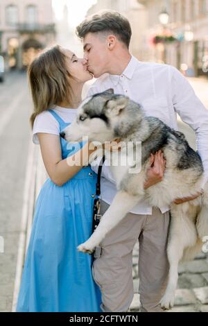 Adorable couple caucasien amoureux, habillé dans une tenue décontractée élégante, embrassant et embrassant en plein air dans la ville, s'amuser et passer du temps avec Banque D'Images