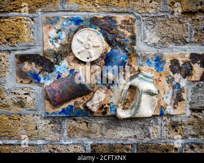 Sculpture d'emballages de déchets incrustés dans un mur de briques, Greenwich Banque D'Images