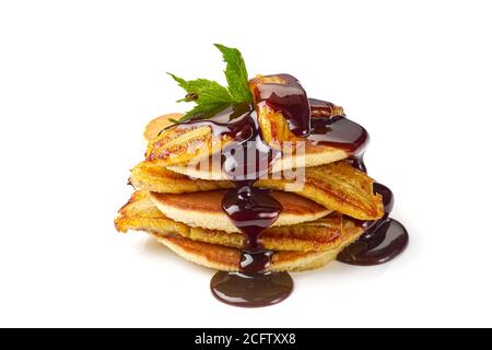 Pile de crêpes avec banane frite, feuille de menthe et sirop de chocolat sur blanc Banque D'Images