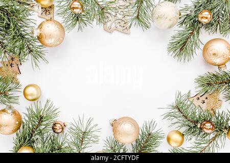 Cadre de Noël, motif en or et boules de Noël en verre doré sur fond blanc. Concept de fêtes et de célébrations. Vue de dessus. Pose à plat Banque D'Images