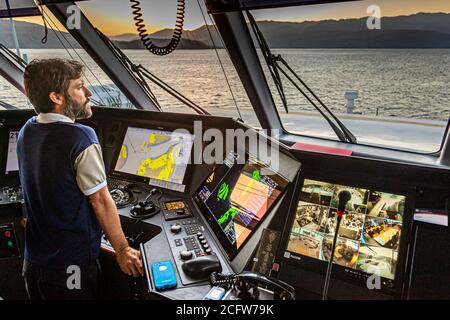 Avec le capitaine sur le pont pendant la croisière de tir et de dragons du Nord vrai, îles Sunda, Indonésie Banque D'Images