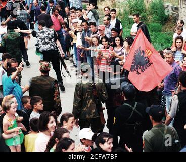 Les membres de la section locale de l'Armée de libération du Kosovo, l'UCK, marche dans les rues de Koretin, du Kosovo à l'honneur des Marines (la 26e Marine Expeditionary Unit (MEU). Banque D'Images