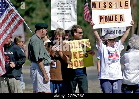 2001 - les manifestants portant des drapeaux américains et chante bordent la rue près de l'entrée principale à Vandenberg AFB, CA de participer à une manifestation prévue, au cours de la Journée internationale de protestation pour arrêter la militarisation de l'espace Banque D'Images